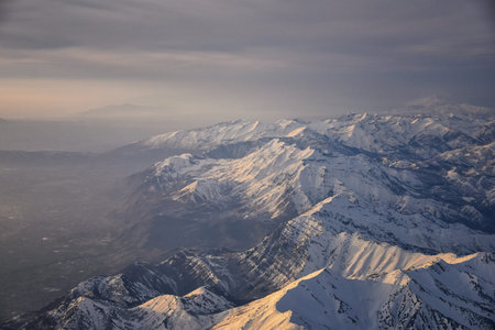 Aerial view from airplane of the Wasatch Front Rocky Mountain Range with snow capped peaks in winter...