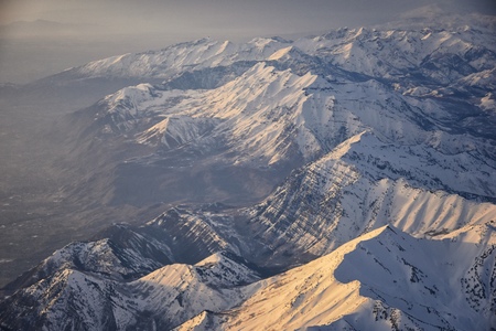 Aerial view from airplane of the Wasatch Front Rocky Mountain Range with snow capped peaks in winter including urban cities of Provo, Farmington Bountiful, Orem and Salt Lake City. Utah. United States.の写真素材
