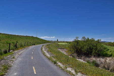 Jordan River Parkway Trail, Redwood Trailhead bordering the Legacy Parkway Trail, panorama views with surrounding trees and silt filled muddy water along the Rocky Mountains, Salt Lake City, Utah.の写真素材