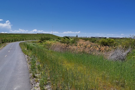 Jordan River Parkway Trail, Redwood Trailhead bordering the Legacy Parkway Trail, panorama views with surrounding trees and silt filled muddy water along the Rocky Mountains, Salt Lake City, Utah.の写真素材