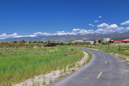 Jordan River Parkway Trail, Redwood Trailhead bordering the Legacy Parkway Trail, panorama views with surrounding trees and silt filled muddy water along the Rocky Mountains, Salt Lake City, Utah.の写真素材