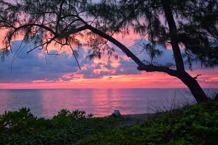 Phuket beach sunset, colorful cloudy twilight sky reflecting on the sand gazing at the Indian Ocean, Thailand, Asia.の写真素材