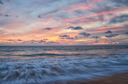 Phuket beach sunset, colorful cloudy twilight sky reflecting on the sand gazing at the Indian Ocean, Thailand, Asia.の写真素材