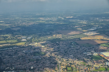 England rural landscape, fields, meadows and clouds. Aerial view from airplane of endless lush...