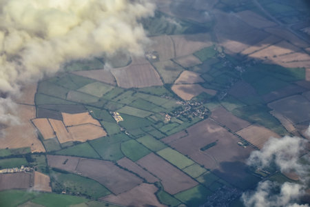 England rural landscape, fields, meadows and clouds. Aerial view from airplane of endless lush...