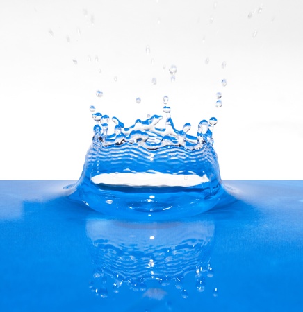 Blue water splash crown with reflection on white backgroundの写真素材