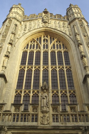 West front facade of Bath Abbey. Large stain glass window set in ornately carved stone surround. 16th Century church, Bath, England, United Kingdomの写真素材