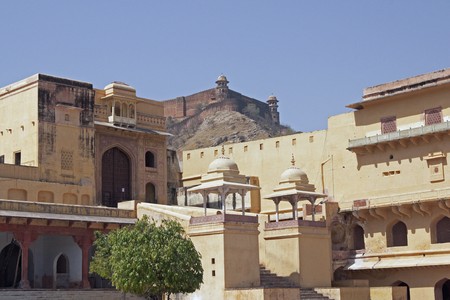Courtyard (Jaleb Chowk) inside Amber Fort. Large honey coloured Moghul style building. Jaigarh Fort on the top of the hill in the backgroundの写真素材