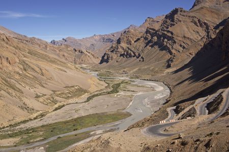 High altitude road climbing a scenic river valley at the Gata Loops between Manali and Leh in Ladakh, Indiaの写真素材