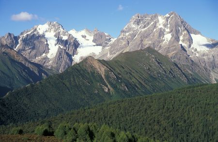 Snow capped mountains and forested hills of Yunnan Province in Chinaの写真素材