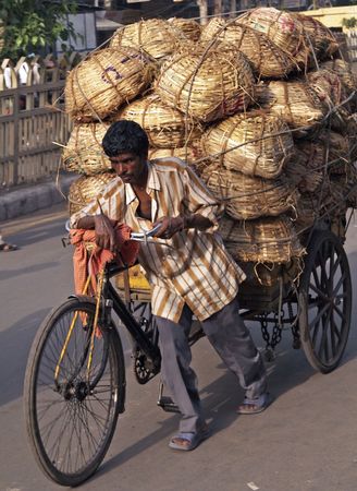 Old Delhi, India - June 25, 2006: Man pushing heavily loaded cycle rickshaw through the streets of Old Delhi, India のeditorial素材