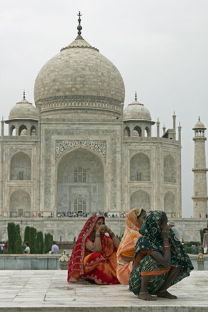 Agra, Uttar Pradesh, India - July 26, 2008: Indian ladies in colorful sari's squatting on a white marble plinth at the Taj Mahal in Agra, Uttar Pradesh, Indiaのeditorial素材
