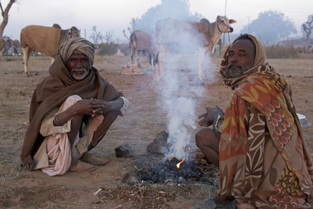 Nagaur, Rajasthan, India - February 16, 2008: Indian men wrapped in blankets clustered around an open fire at the Nagaur Cattle Fair, Rajasthan, Indiaのeditorial素材