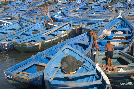 Essaouira, Morocco - August 27, 2009: Young men at work on a fleet of wooden fishing boats in the fishing village of Essaouira, Morocco.のeditorial素材