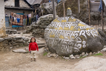 Himalaya Mountains, Nepal - May 9, 2010: Girl playing with a gun in a remote mountain village in Nepalのeditorial素材