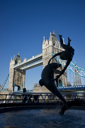 London, England - July 24, 2011: Tower Bridge in London, England. Silhouette of a statue of a dolphin and person in the foreground.のeditorial素材