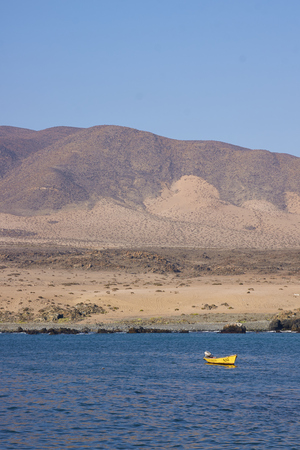 Small inshore fishing boat in the bay at the small fishing village of Carrizal Bajo off the coast of the Atacama Desert in Chileの写真素材