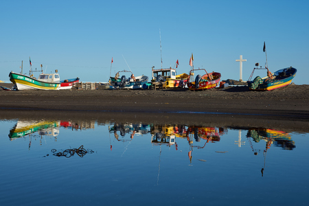 Curanipe Chile  April 21 2015: Colourful fishing boats reflected in a river in the small fishing town of Curanipe Chile.のeditorial素材