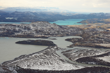Winter landscape of lakes and snow covered hills and mountains in Torres del Paine National Park in Patagonia, Chile.の写真素材