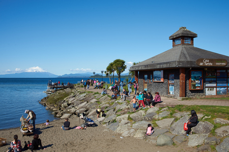 PUERTO VARAS, CHILE - OCTOBER 16, 2015: People on a sandy beach on the shore of Llanquihue Lake in Puerto Varas, Southern Chile. Snow capped Volcano Osorno 2,652 metres in the distance.のeditorial素材