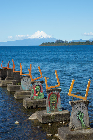 PUERTO VARAS, CHILE - OCTOBER 16, 2015: Murals decorating a derelict pier on Llanquihue Lake in Puerto Varas, Southern Chile. Snow capped Osorno 2,652 metres  in the distance.のeditorial素材