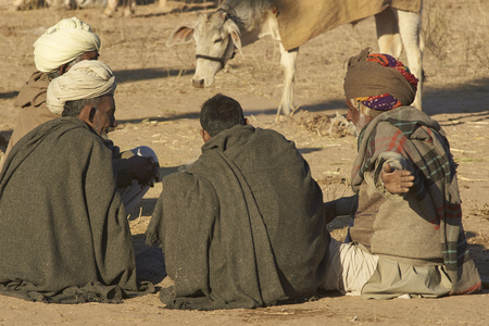 Nagaur, Rajasthan, India - February 14, 2008: Preparing food and arming up after a cold night camping at the annual livestock festival in Nagaur, Rajasthan, India.のeditorial素材