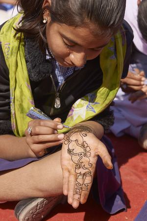 Nagaur, Rajasthan, India - February 14, 2008: Girls decorating hands with henna during the annual livestock festival in Nagaur, Rajasthan, India.のeditorial素材