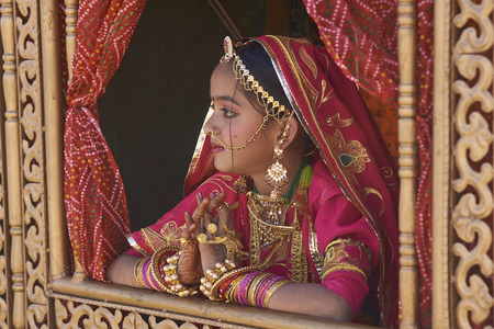 Jaisalmer, Rajasthan, India - February 19, 2008: Teenage girl in traditional costume being paraded through the historic quarter during the annual Desert Festival in Jaisalmer, Rajasthan, India.のeditorial素材