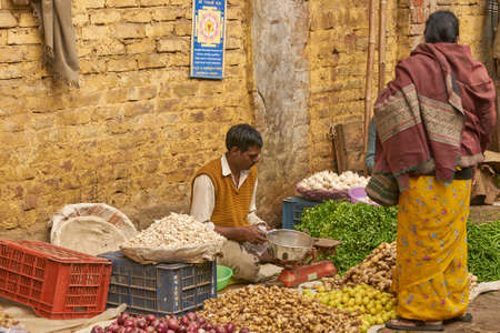 DELHI, INDIA - FEBRUARY 5, 2009: Man selling vegetables at a street market in Old Delhi, India.のeditorial素材