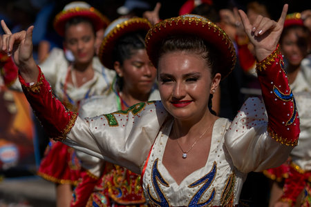 Arica, Chile - January 23, 2016: Female members of a Caporales dance group in ornate red and white...