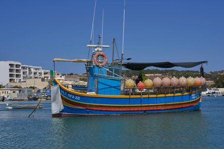 Marsaxlokk, Malta - June 7, 2023: Traditional fishing boats in the harbour of the historic fishing town of Marsaxlokk in Maltaのeditorial素材