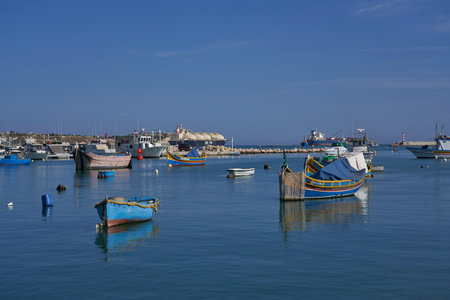 Marsaxlokk, Malta - June 7, 2023: Traditional fishing boats in the harbour of the historic fishing town of Marsaxlokk in Maltaのeditorial素材