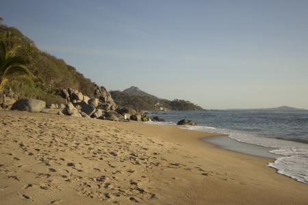 tropical beach with sand and mountainsの写真素材