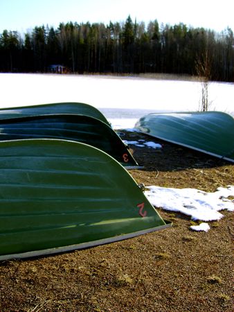 Row boats next to frozen lakeの写真素材