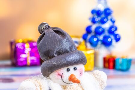 Snowman in foreground. Christmas collection, gifts and decorative ornaments. Holiday Season background with decorations. Blue, green xmas trees. Gift boxes various colours. Copy space for text.の写真素材