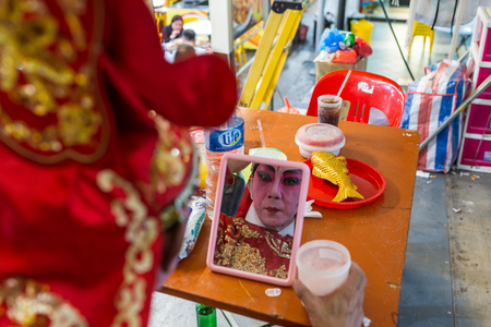 Asia Chinese Teochew Opera. Artiste putting on makeup, preparing for public performance. Traditional heritage arts.のeditorial素材