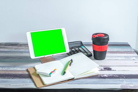 Office and school stationery supplies, reusable cup and mobile tablet with green screen. Business Objects Technology concept.の写真素材