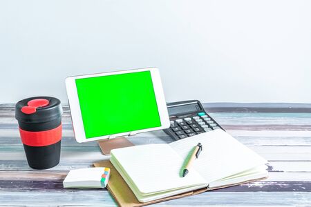 Office and school stationery supplies, reusable cup and mobile tablet with green screen. Business Objects Technology concept.の写真素材