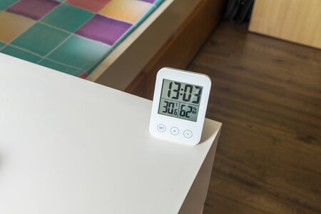 Indoor electronic LCD digital clock with humidity temperature sensor display device. White daily life object home appliance.の写真素材