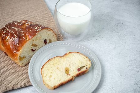 Breakfast brunch on table. Loaf, one slice of bread on plate and cup of fresh milk.の写真素材