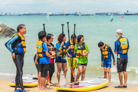 Group of men and women windsurfers on beach having discussionのeditorial素材