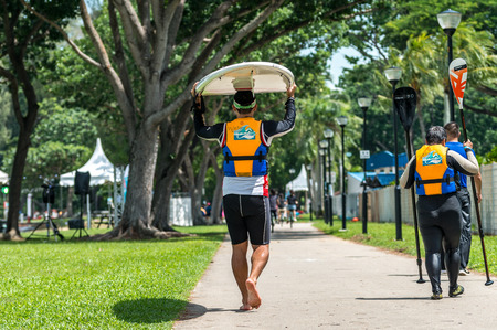 Back view of two surfers people man carry surf board woman hold a pair of oarsのeditorial素材