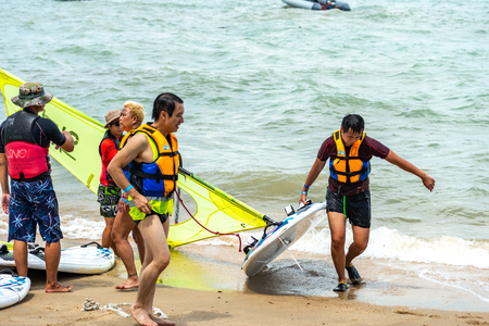 Men and women windsurfers carry boards after surfingのeditorial素材