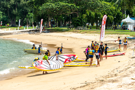 Men and women windsurfers carry boards after surfingのeditorial素材