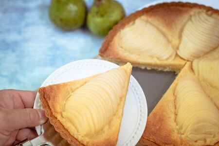 Delicious home bake poached pear tart pie, as known as Tarte Bourdaloue, a cup of coffee latte. It is a french popular recipe that gets the name from a street in Paris. Breakfast, brunch, afternoon food on table concept.の写真素材