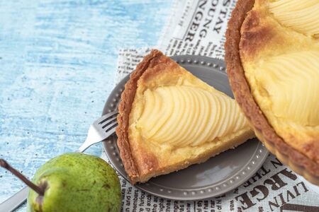 Delicious home bake poached pear tart pie, as known as Tarte Bourdaloue, a cup of coffee latte. It is a french popular recipe that gets the name from a street in Paris. Breakfast, brunch, afternoon food on table concept.の写真素材