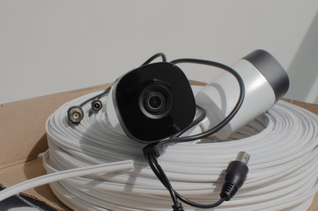 Close-up of a security camera with a roll of wire, ensuring surveillance and security in commercial...