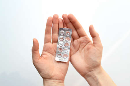 Packaging pills in hand close-up on a white background. treatment with medicines. Treatment with antibioticsの写真素材