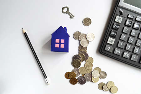 Mortgage concept with stack coins and paper at home and calculator. Saving to buy a house, saving money. The concept of a mortgage. Investing in real estate.の写真素材