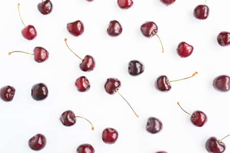 Background from ripe cherries on a white. juicy berries. Red cherries on white. Berry season.の写真素材